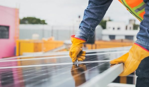pexels-photo-8853537-8853537-1 A solar technician performing maintenance on solar panels outdoors.